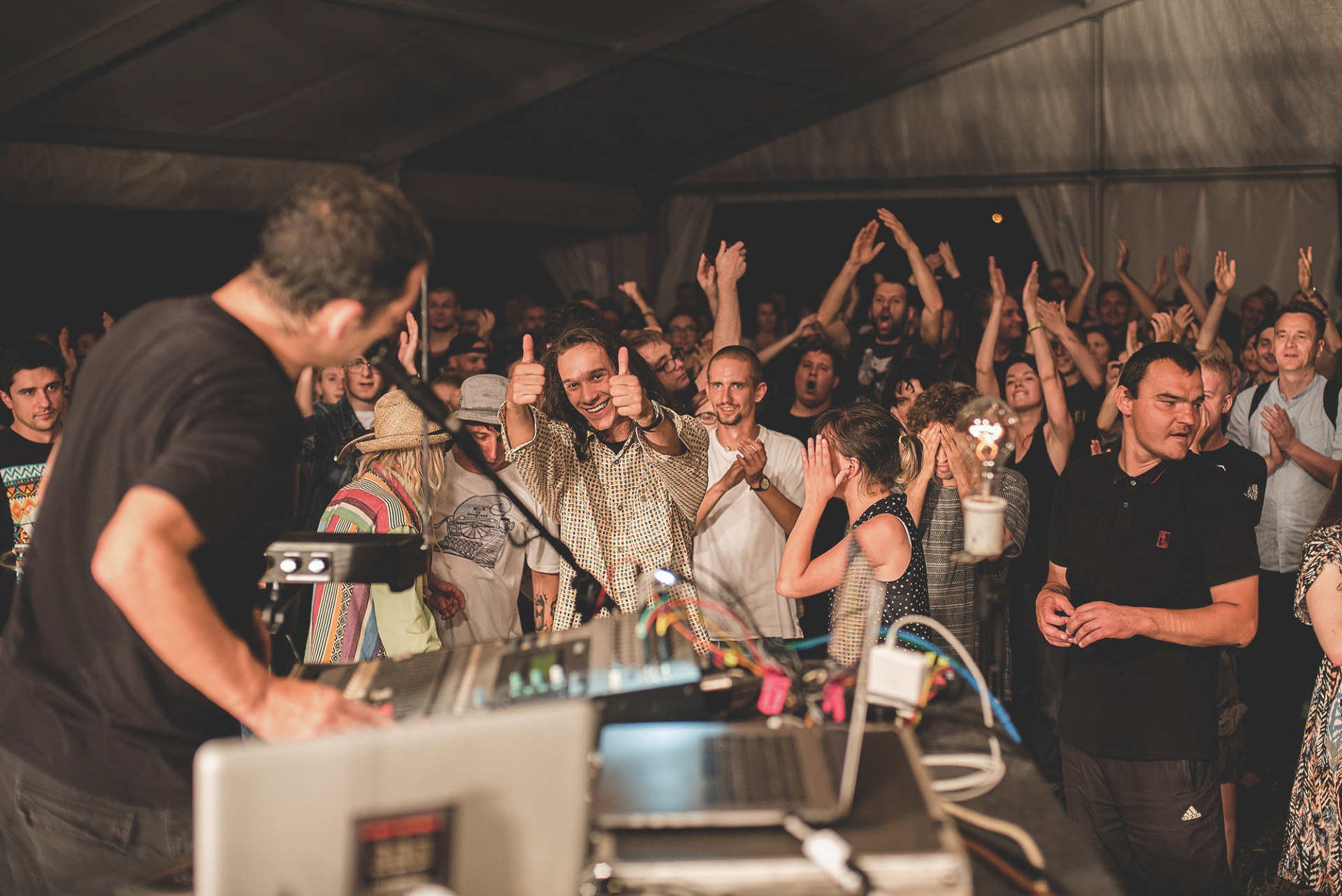 Młodzi ludzie skaczą pod sceną i machają rękami. Młodzi ludzie skaczą pod sceną i machają rękami.