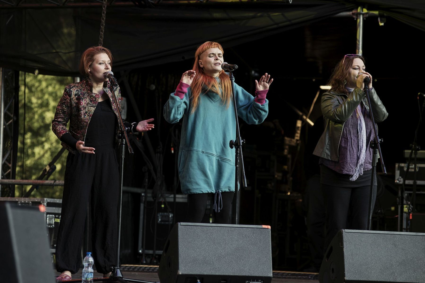 Trzy kobiety śpiewają na scenie.