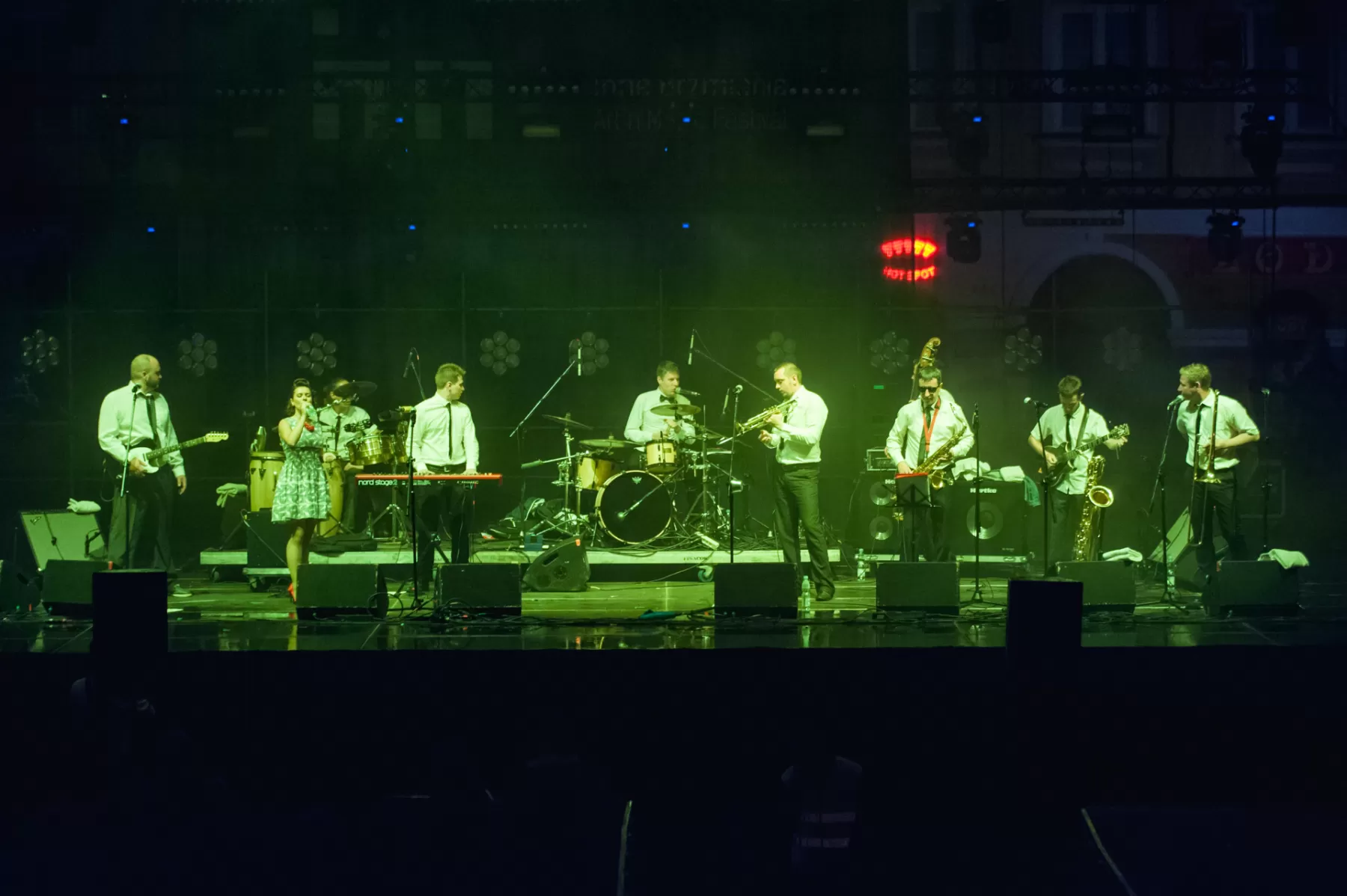 Zespół gra na scenie. To dziewięć osób.