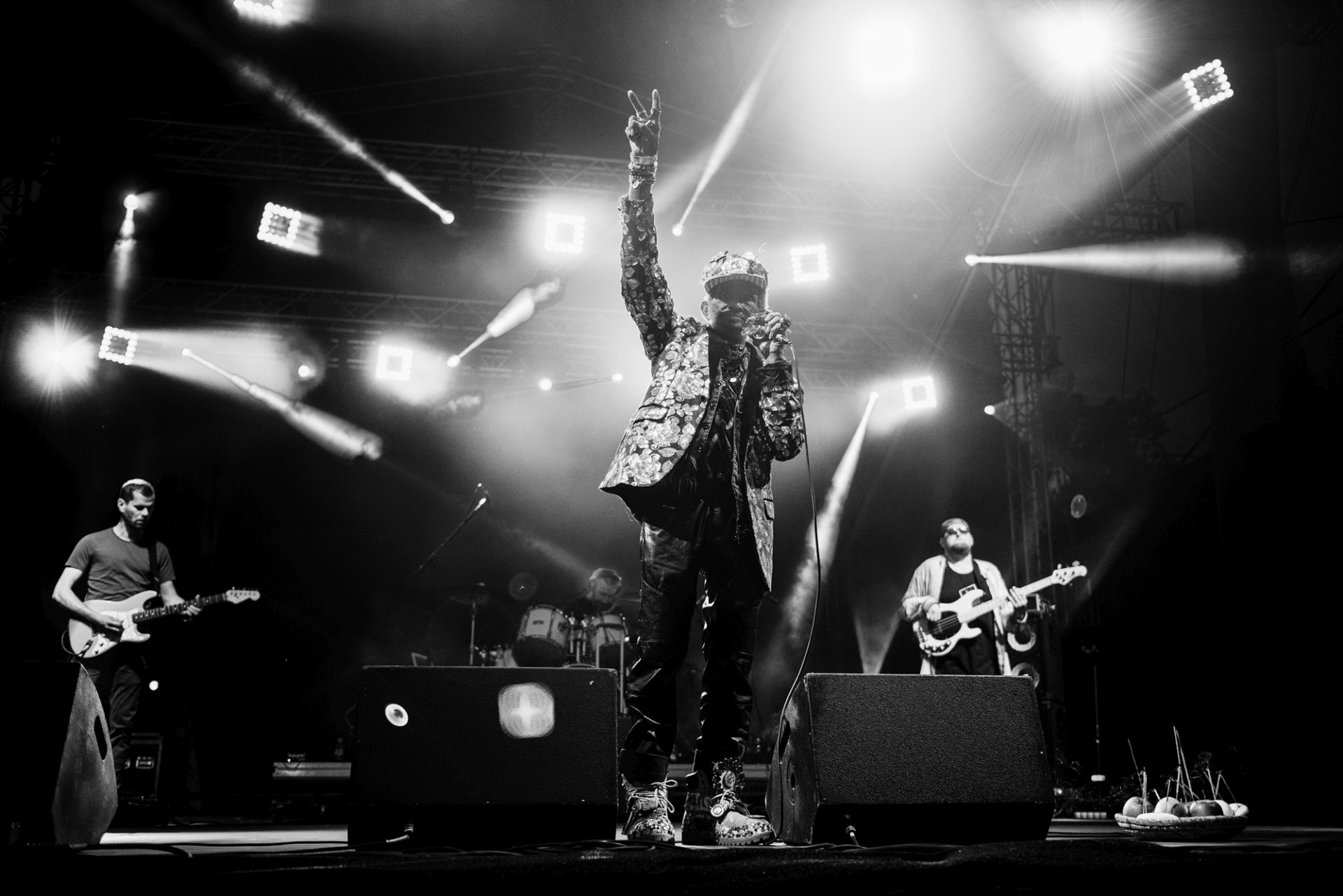 Czarno-biała fotografia z wokalistą na pierwszym planie.