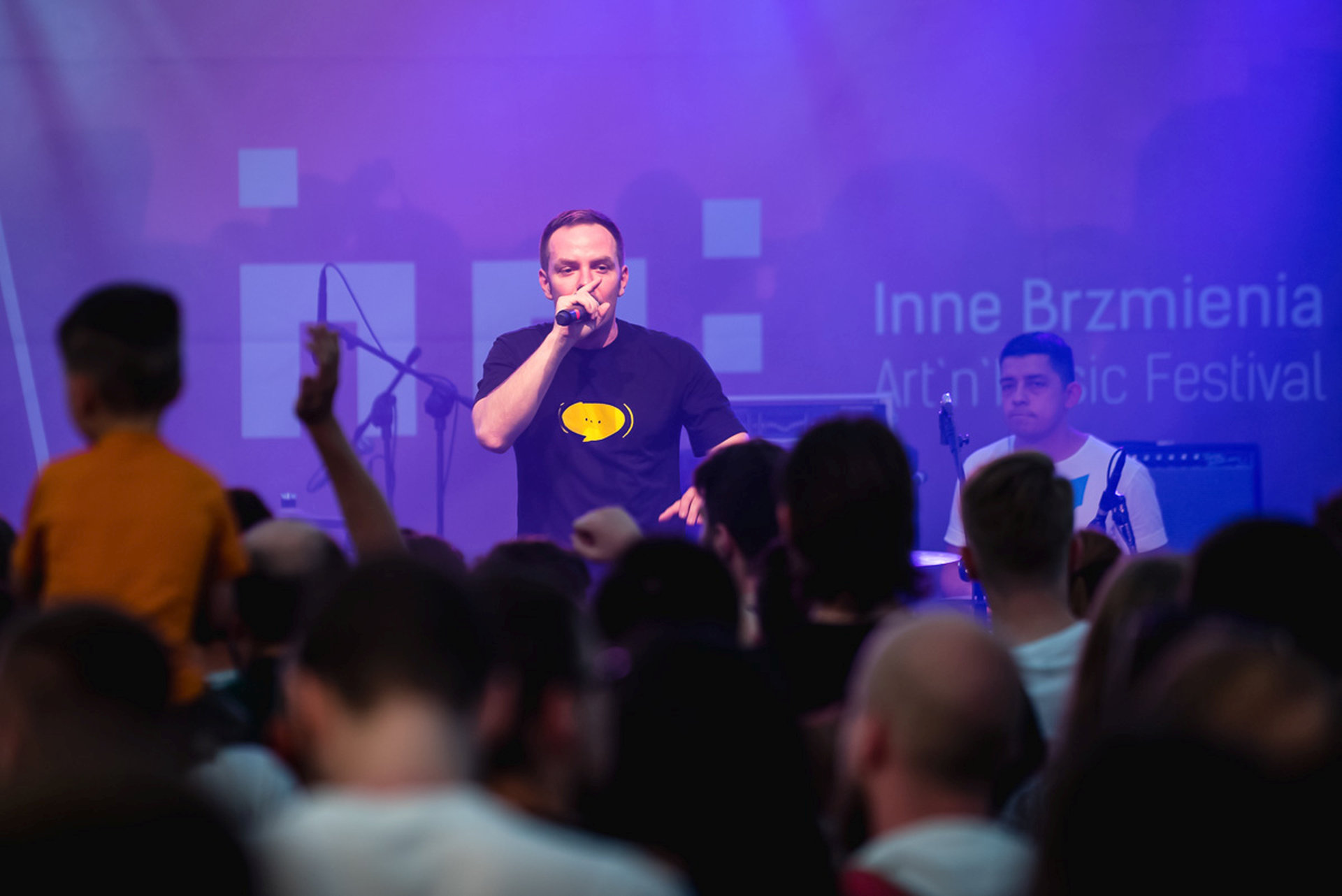 Wokalista śpiewa przed publicznością.