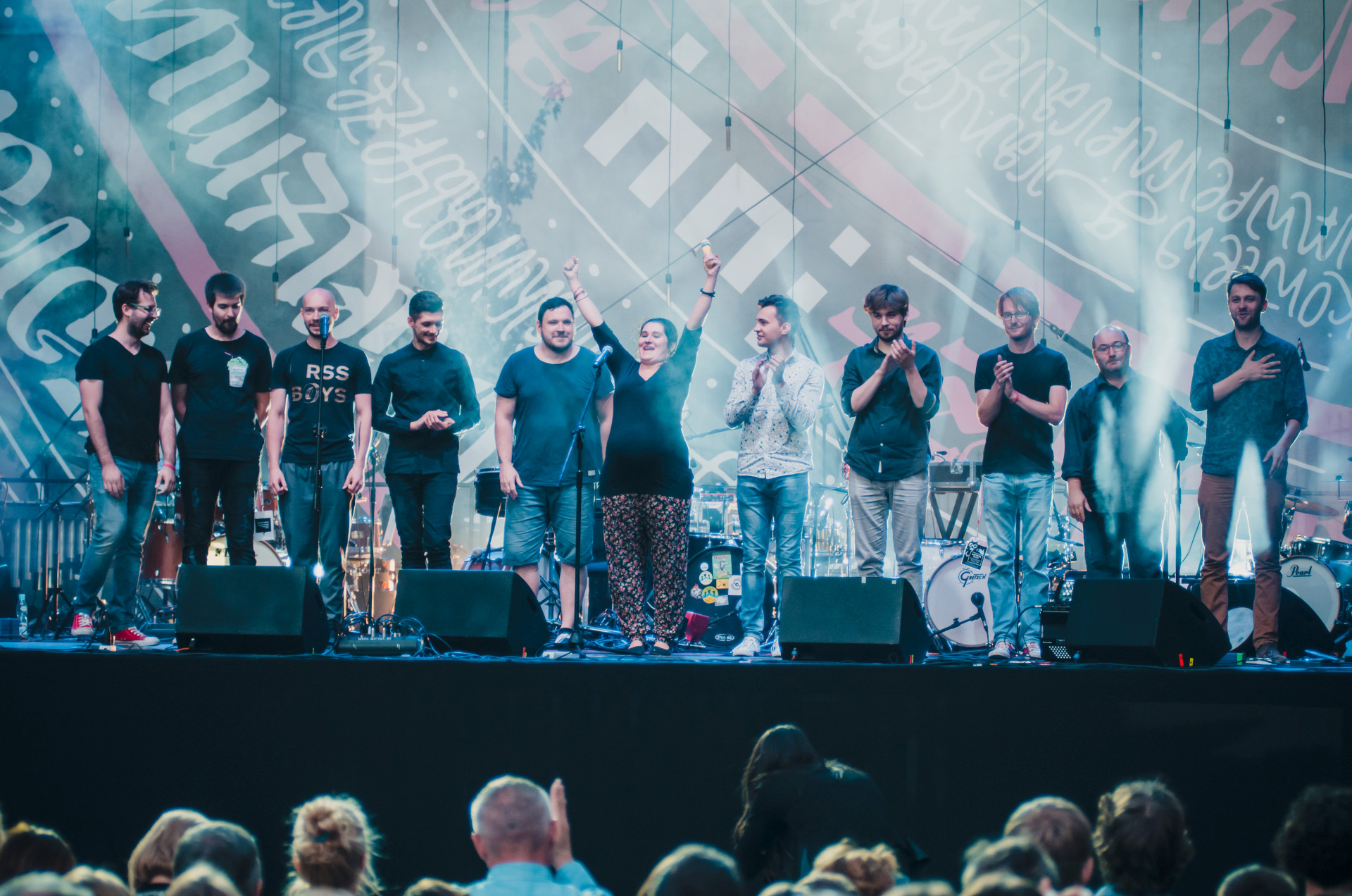 Na scenie stoi 11 artystów i artystek, którzy kłaniają się publiczności.