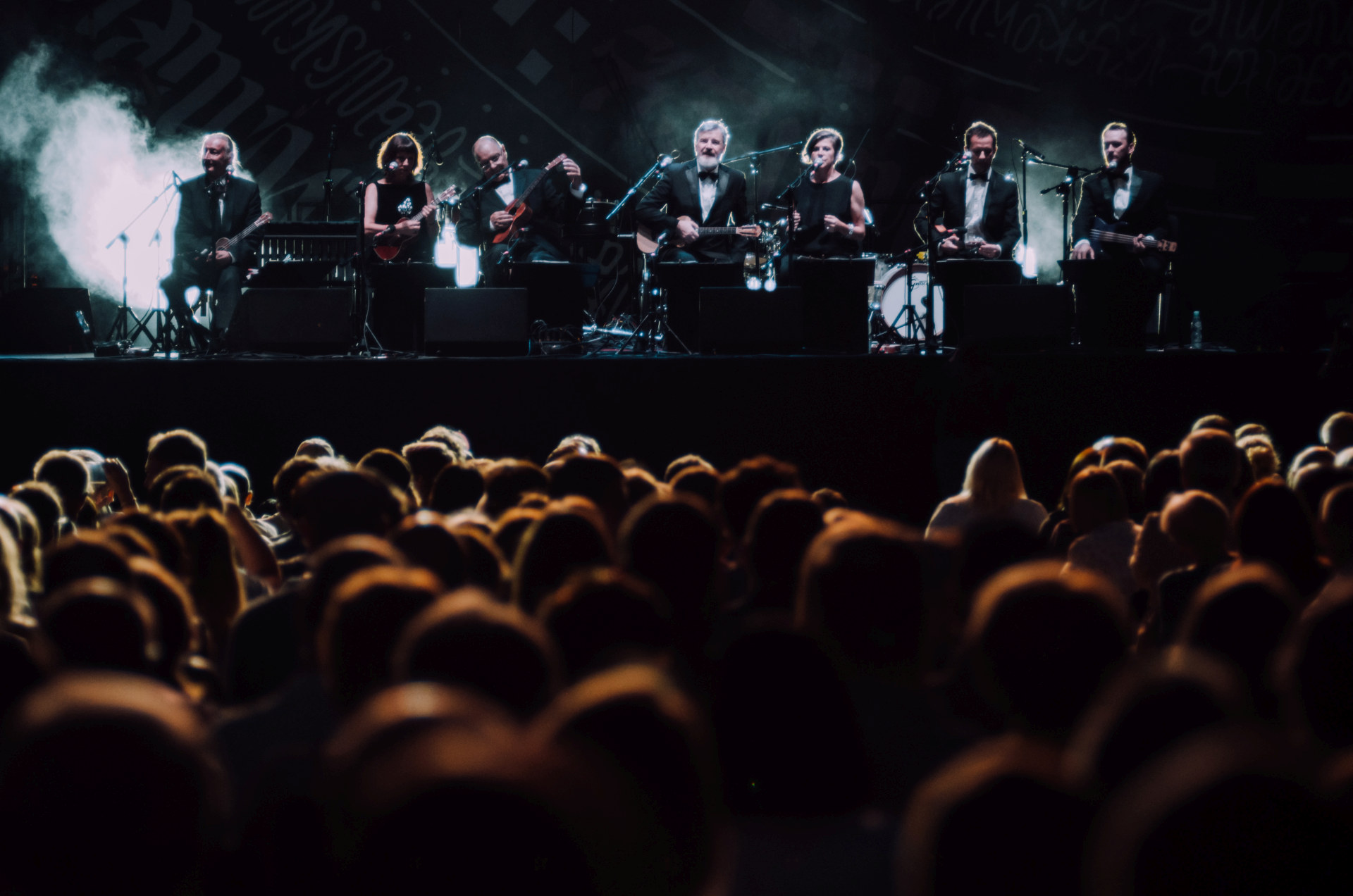 Na scenie jest siedmioro artystów. Wszyscy ubrani są w garnitury.