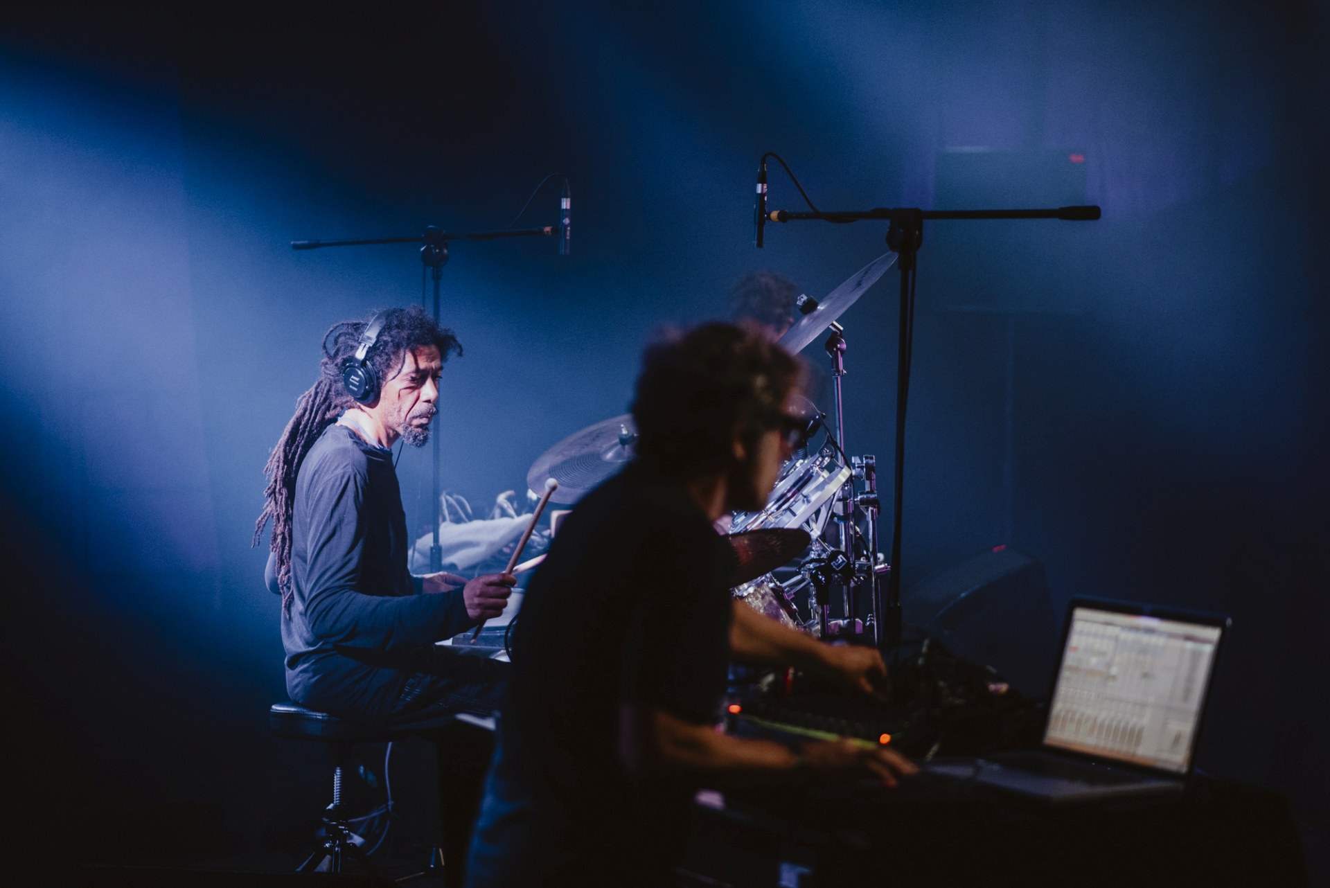 Na scenie jest perkusista oraz mężczyzna obsługujący konsolę.